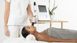 Woman receiving skin exfoliation with a Geneo facial treatment at a spa