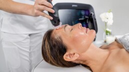 Woman receiving Geneo facial treatment for textured skin, uneven skin tone